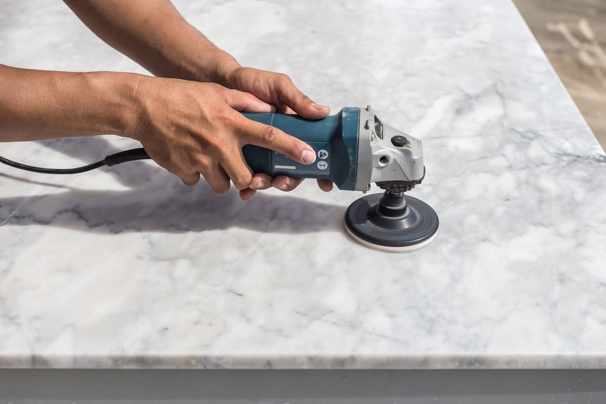 MarblePros technician hand-polishing a marble surface on site